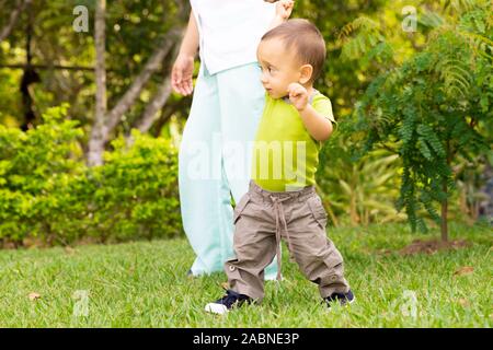 Happy Toddler Boy Laufen lernen im Gras Stockfoto