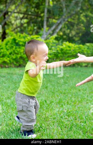 Happy Toddler Boy Laufen lernen im Gras Stockfoto