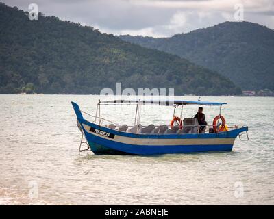 Penang, Malaysia - November 2019 - Boot warten in der Nähe der Ufer in Batu Ferringhi Stockfoto