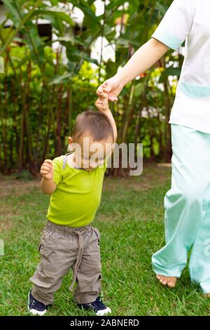 Happy Toddler Boy Laufen lernen im Gras Stockfoto