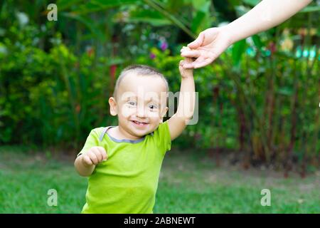 Happy Toddler Boy Laufen lernen im Gras Stockfoto