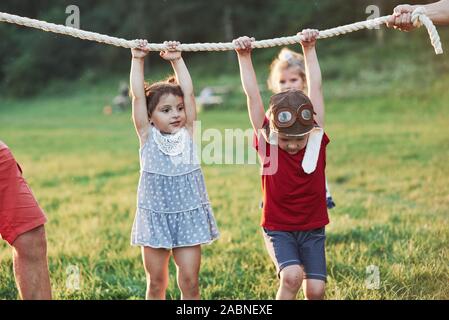 Interessant, wie viel von uns Papa auf dem Seil halten kann. Ziehen Sie ein Seil Spiel so viel Spaß. Das ist war es sieht aus wie gute Eltern, die wie die Natur zu haben Stockfoto