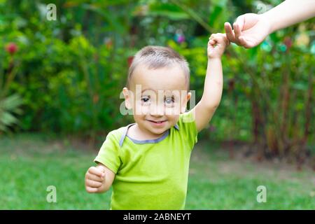 Happy Toddler Boy Laufen lernen im Gras Stockfoto