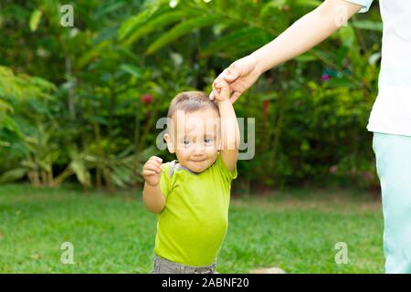 Happy Toddler Boy Laufen lernen im Gras Stockfoto