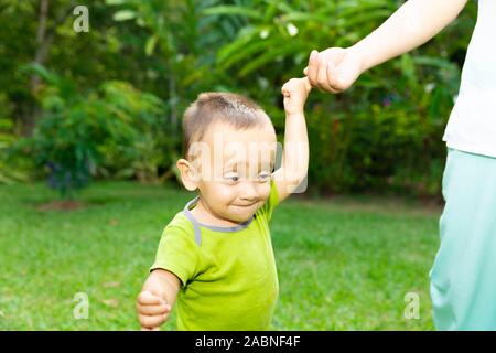 Happy Toddler Boy Laufen lernen im Gras Stockfoto