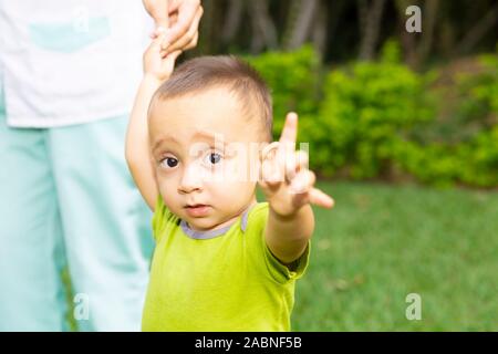 Happy Toddler Boy Laufen lernen im Gras Stockfoto
