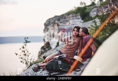 Lassen Sie uns selfie nehmen. Zwei Personen sitzen auf den Felsen und beobachtete die traumhafte Natur Stockfoto