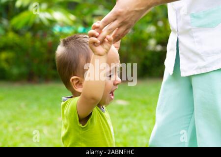 Happy Toddler Boy Laufen lernen im Gras Stockfoto
