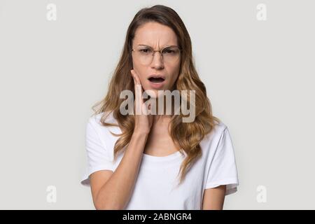 Unglücklich geschockt junge Frau mit Brille mit offenen Mund Stockfoto
