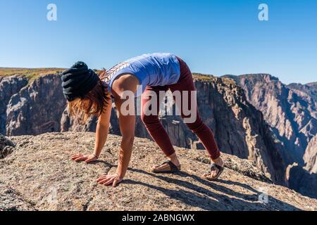 Schöne Frau macht Handstand an der schwarzen Schlucht des Gunnison Stockfoto