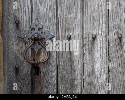 Schmiedeeiserne Tür-Klopfer verwitterte alte Holztür mit versilberten Korn der Kirche in Bradfield, Sheffield, South Yorkshire, England, Großbritannien Stockfoto