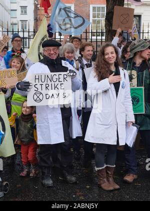 Aussterben Rebellion Wissenschaftler zeigen Solidarität mit Hunger markante Demonstranten vor der Konservativen Partei Hauptsitz in London. Stockfoto