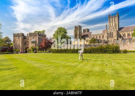 Krocket wird regelmäßig auf der großen Rasenfläche innerhalb der Mauern der Palast des Bischofs in Wells, Somerset, England, UK gespielt Stockfoto