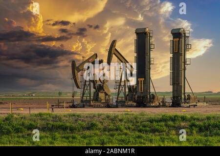 Jack Pumpen in Betrieb und Gewitterwolken in der Bakken spielen Ölfelder in der Nähe von Williston, North Dakota, USA. Stockfoto