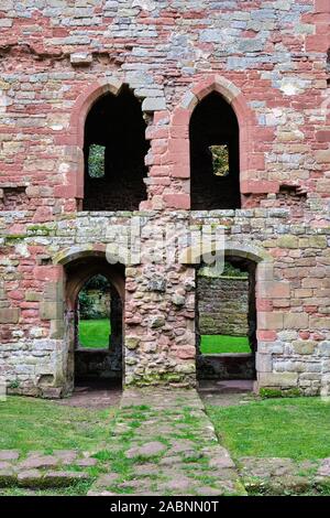 Symmetrische gewölbten Fenstern und Türen auf zwei Ebenen in einem zerstörten roten Sandstein Mauer in die Überreste von Acton Burnell Schloss in Shropshire England Stockfoto