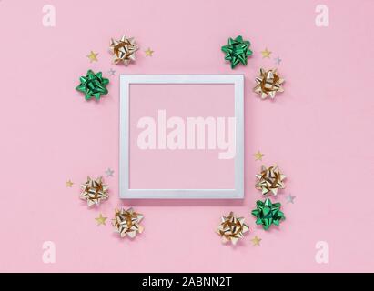 Weihnachtsfeier mockup mit Rahmen, Bögen und Sterne auf einem rosa Hintergrund, mit kopieren. Ansicht von oben flach. Stockfoto