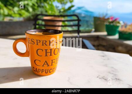 Große orange Kaffee Tasse auf den Tisch und Natur panorama Stockfoto