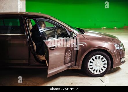 Straßburg, Frankreich - Dec 21, 2016: Seitenansicht des Luxus Skoda Octavia Auto in Leere u-bahn grüne Wand parken und weibliche Silhouette Schließen der Fluggäste Tür geparkt Stockfoto