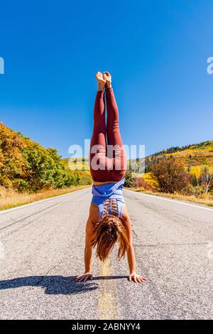 Schöne Frau macht Handstand an der schwarzen Schlucht des Gunnison Stockfoto