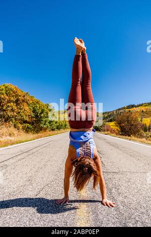 Schöne Frau macht Handstand an der schwarzen Schlucht des Gunnison Stockfoto