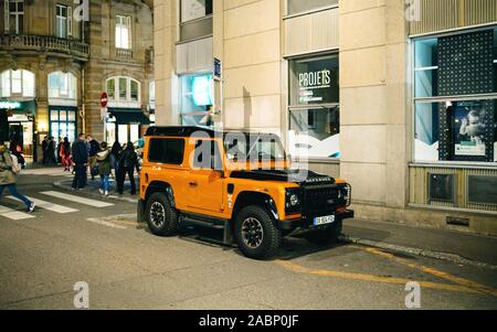 Straßburg, Frankreich - 23.November 2017: Seitenansicht des Luxus Orange Range Rover Defender SUV auf Französische Straße Fußgänger im Hintergrund geparkt Stockfoto