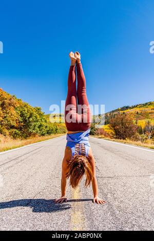 Schöne Frau macht Handstand an der schwarzen Schlucht des Gunnison Stockfoto