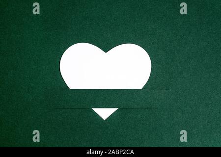 Herz aus Papier ausgeschnitten auf Grün Foto Karton Stockfoto