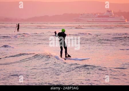 Beachlands, Hayling Island, Hampshire, UK. 28. November 2019. Ein schöner Ausklang des Tages für die Südküste. Paddleboarders genießen die Wellen aus Hayling Island in Hampshire bei Sonnenuntergang. Credit: James Jagger/Alamy leben Nachrichten Stockfoto