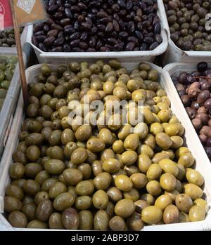 Grün und Kalamata Oliven zum Verkauf in Kunststoffbehältern in einem offenen Markt in Tirana, Albanien. Stockfoto