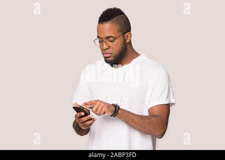 Schwere afrikanische amerikanische Mann mit Telefon, bei Bildschirm schaut Stockfoto