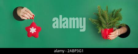 Alternative Weihnachtsbaum und spürte rote Stern als Dekor in der Frau die Hände von runde Öffnung im Grünbuch. Xmas-Banner, Platz für Text. Verkauf dekorative Kugel Stockfoto