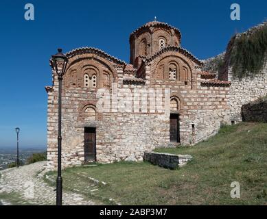 Berat, Albanien - September 28, 2019: Mittelalterliche byzantinische Kirche der Heiligen Dreifaltigkeit mit Stein und Ziegel mit einem gepflasterten Weg gesäumt von Stree gebaut Stockfoto