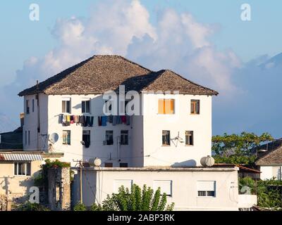 In Pogradec, Albanien - September 26, 2019: Nahaufnahme von einem traditionellen, weiß getünchten Stuck Apartment Gebäude. Wäsche hängt an einer Wäscheleine. Stockfoto