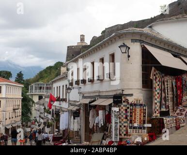 In Pogradec, Albanien - 26. September 2019: Fußgängerzone mit Menschen Shopping in Souvenirläden in Gjirokaster Albanien mit der Festung und castl Stockfoto