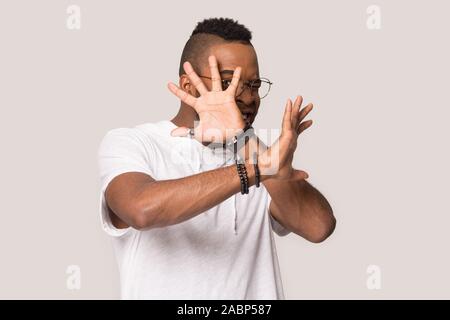 Erschrocken African American man versteckt sich hinter den Händen, sich weigern, Geste Stockfoto