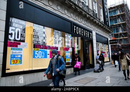 London, Großbritannien. 28 Nov, 2019. Käufer vorbei die Schließung Zeichen in das Fenster der Ewigkeit 21 Store auf der Oxford Street in London. Quelle: Steve Taylor/SOPA Images/ZUMA Draht/Alamy leben Nachrichten Stockfoto