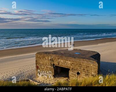 Junger Mann Fotos von Überresten einer WW2 Bunker mit Graffiti an einer französischen Strand Stockfoto