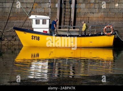 Kleine helle gelbe Fischerboot mit weißen Steuerhaus in Colonsay Hafen, Insel Colonsay, Schottland, UK günstig Stockfoto