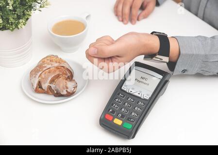 Mann mit smart Watch im Restaurant zu bezahlen. NFC contactless bequeme Zahlung Service Stockfoto