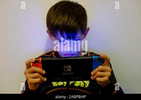 Junge, 9 Jahre, spielen auf dem Nintendo Schalter, Deutschland Stockfoto