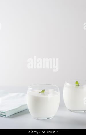Organische probiotischen Milch kefir Drink oder Joghurt in zwei Gläser. Fermentierte Milch trinken. Bild mit Kopie Raum, vertikale Ausrichtung. Stockfoto