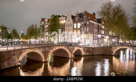 Nacht Blick auf die Grachten, Brücken und Häuser in Amsterdam, Niederlande Stockfoto