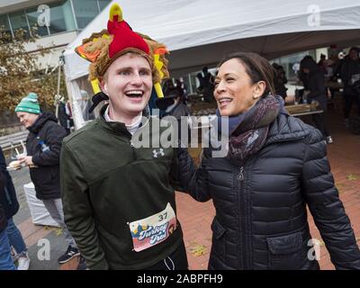 Des Moines, Iowa, USA. 28 Nov, 2019. US-Senator Kamala Harris (D-CA) Gespräche zu einer Person trägt die Türkei hat im Zielbereich der Türkei Trab. Die Türkei Trab ist eine jährliche Des Moines Thanksgiving Tag 5 km Fun Run. Sen Harris Läufer im Ziel begrüßt und übergeben Sie Cookies. Sie läuft der demokratische Kandidat für die US-Präsidentschaft im Jahr 2020. Iowa ist Gastgeber der ersten Auswahl bei den Präsidentschaftswahlen Saison. Die Iowa Caucuses sind Februar 3, 2020. Credit: Jack Kurtz/ZUMA Draht/Alamy leben Nachrichten Stockfoto