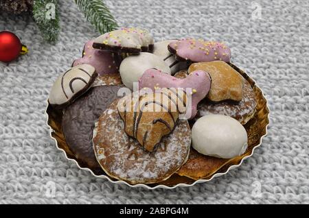 Lebkuchen mit Tannenbaum und red christmas ball Ornament auf goldenen Platte, Nahaufnahme, auf grau Gestricken Hintergrund isoliert Stockfoto