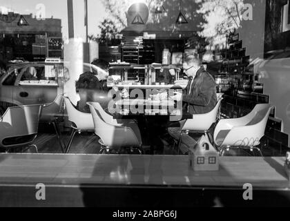 Belgrad, Serbien, 26.November 2019: Eine reflektierende Einblick in eine Snack Bar mit ein Paar in einer Mahlzeit (B&W) Stockfoto