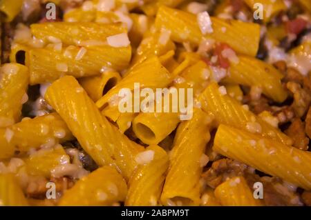 Nahaufnahme einer Platte der italienischen Pasta puttanesca Tortiglioni mit Soße mit Käse Stockfoto