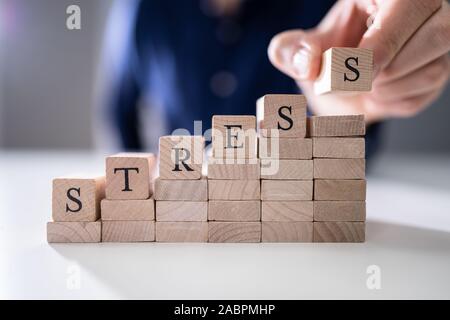 Nahaufnahme der Hand letzte Alphabet der Person des Wortes Stress auf hölzernen Block Stockfoto