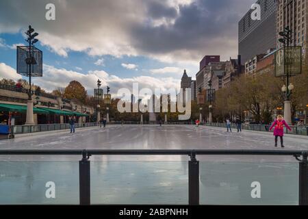 Die Menschen Schlittschuh auf der Millennium Park Ice Rink mit Chicago Skyline und Wolken am Himmel im Hintergrund Stockfoto