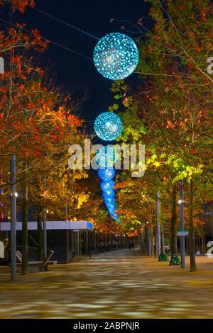 Dieses schöne, von Bäumen gesäumten Pfad durch die Farbe ändern Laternen beleuchtet und ist Teil der Olympic Park 2012 in Stratford, London. Stockfoto