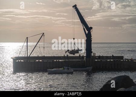 Pier auf der Cascade Bay mit einem Kran liefert Entladen von einer helleren, die sie von einem Mutterschiff offshore verankert hat. Norfolk Island Stockfoto